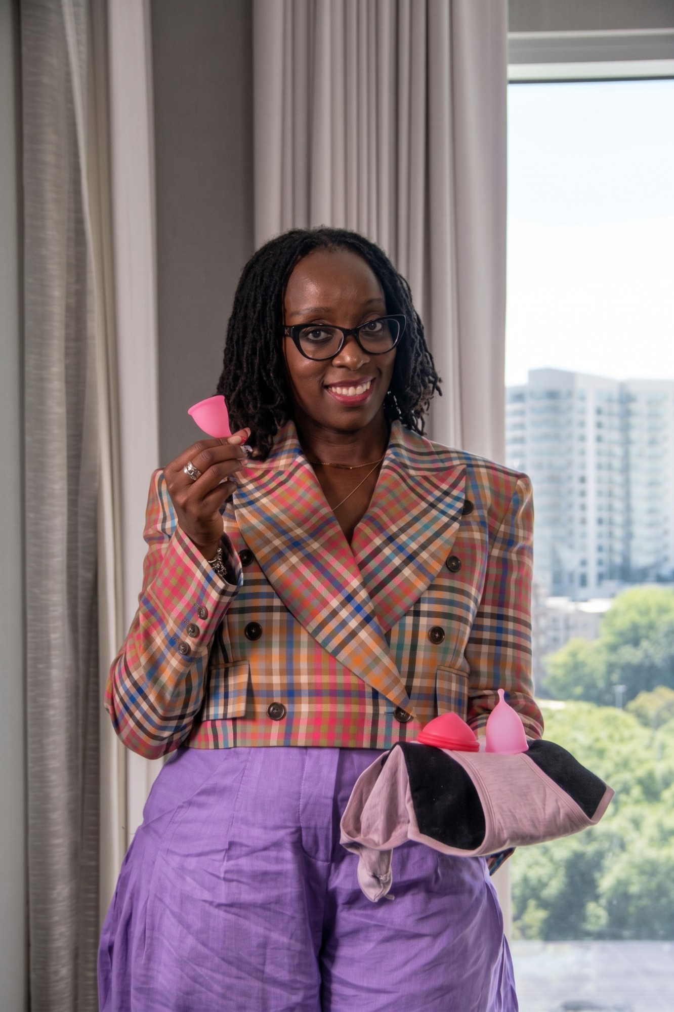 Ednah Sibanda, founder of Imara Flo, holding menstrual cups and period underwear